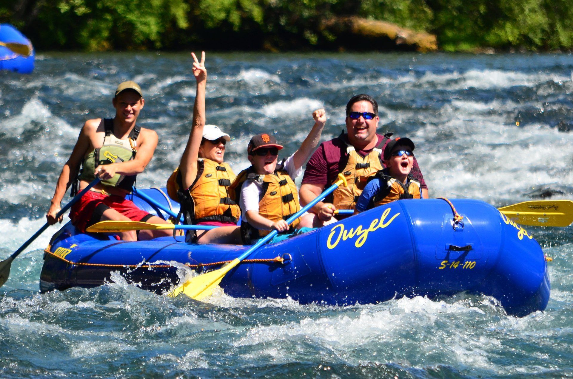 A family enjoying summer rafting adventure on the McKenzie River near Bend, Oregon.