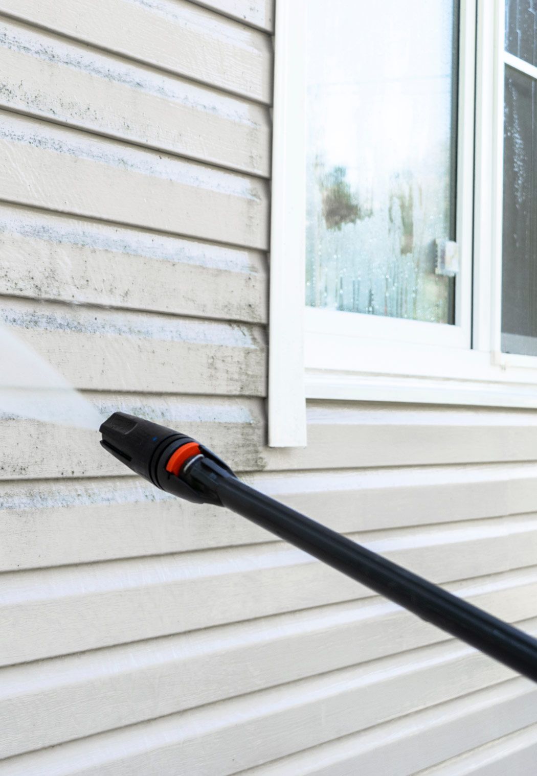 A Person Is Using a High Pressure Washer to Clean the Side of A House — RPS–Remote Painting Services in White Rock, QLD