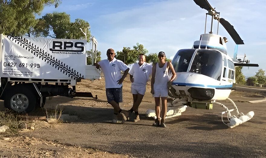 A Group of People Standing in Front of a Helicopter — RPS–Remote Painting Services in White Rock, QLD