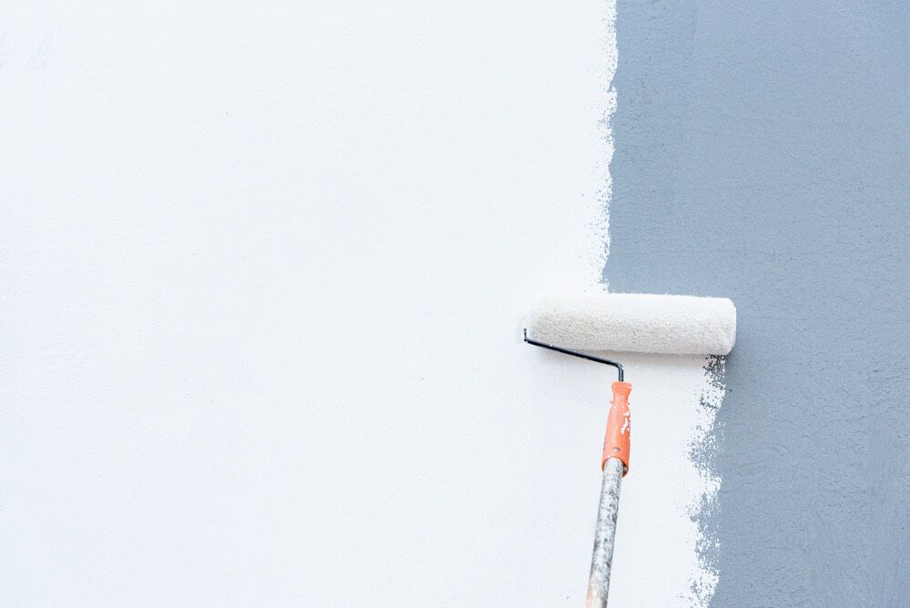 A Paint Roller is Painting a Wall White — RPS–Remote Painting Services in Cassowary Coast, QLD