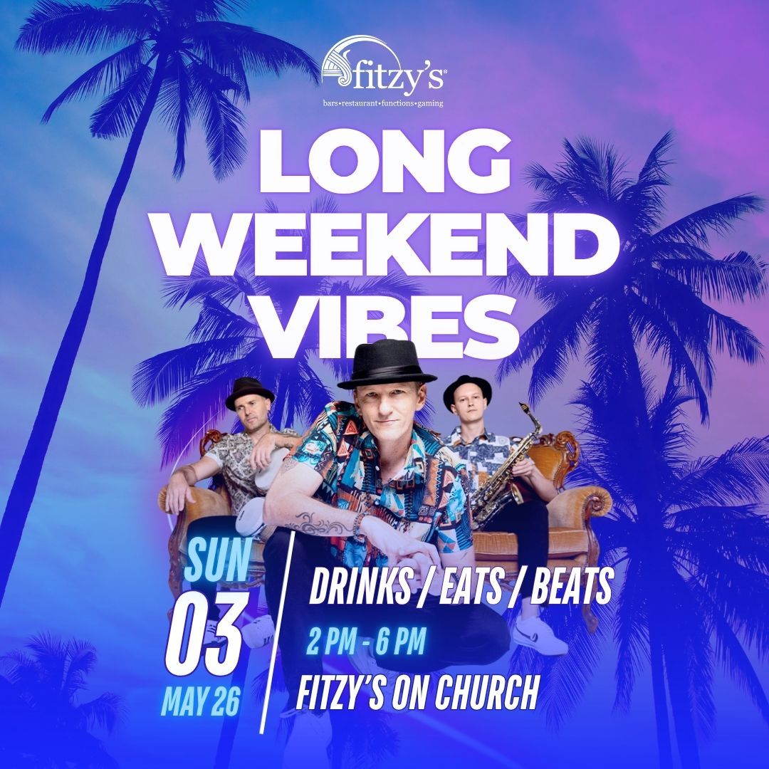 Two smiling individuals wearing sunglasses hold glasses of purple cocktails at an outdoor event with balloons.