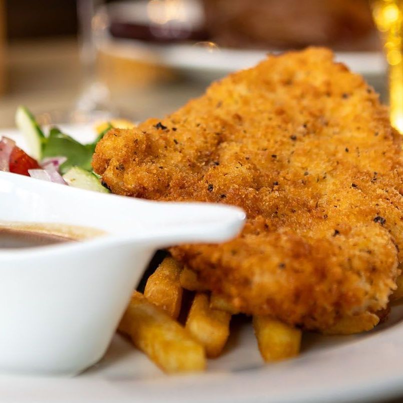A white plate topped with french fries a steak and vegetables