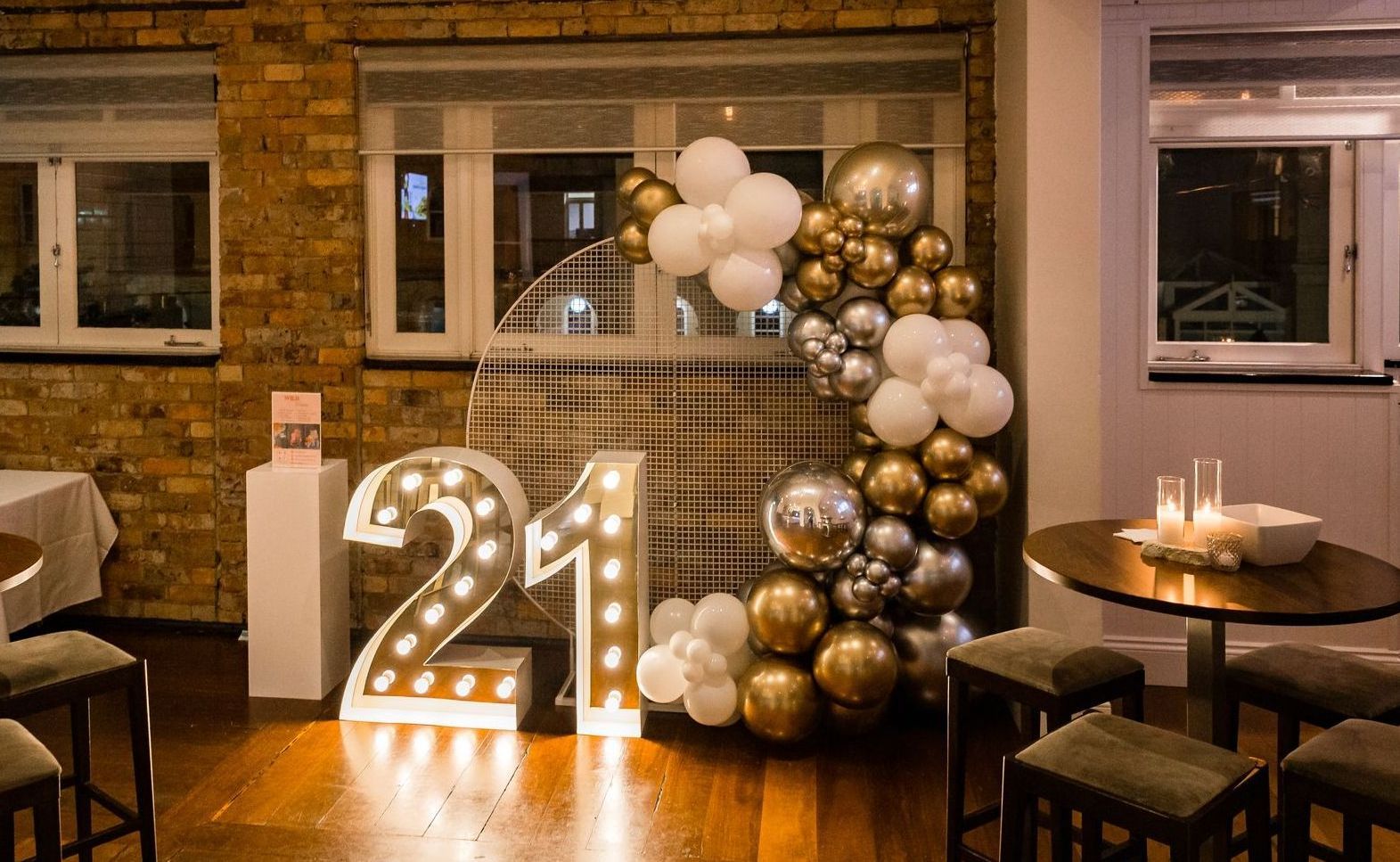 A room decorated with balloons and lights for a 21st birthday party.