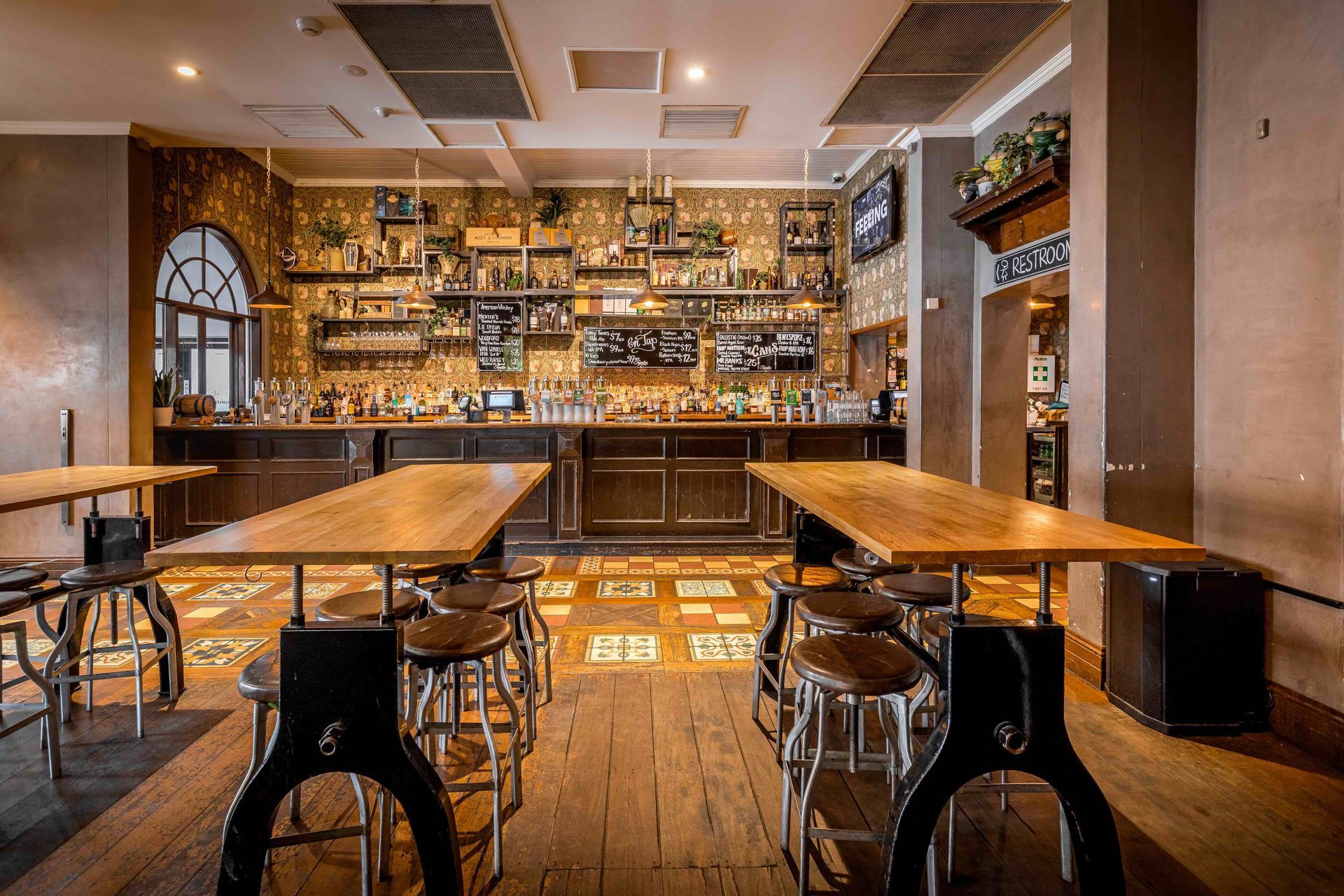 A restaurant with tables and chairs in front of a bar.