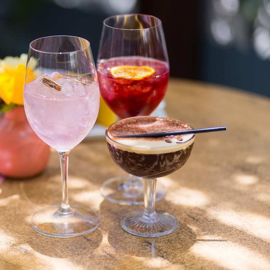 Three different drinks are sitting on a bar counter.