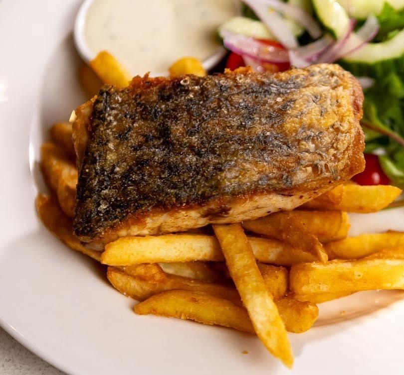 A black bowl filled with pasta and sauce on a table