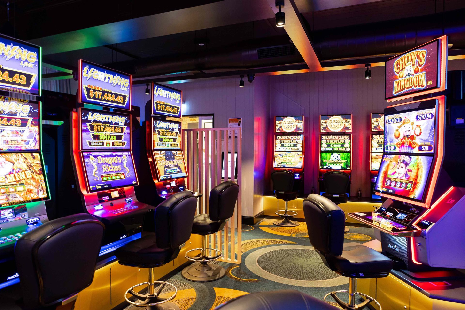 A casino with a lot of slot machines and chairs