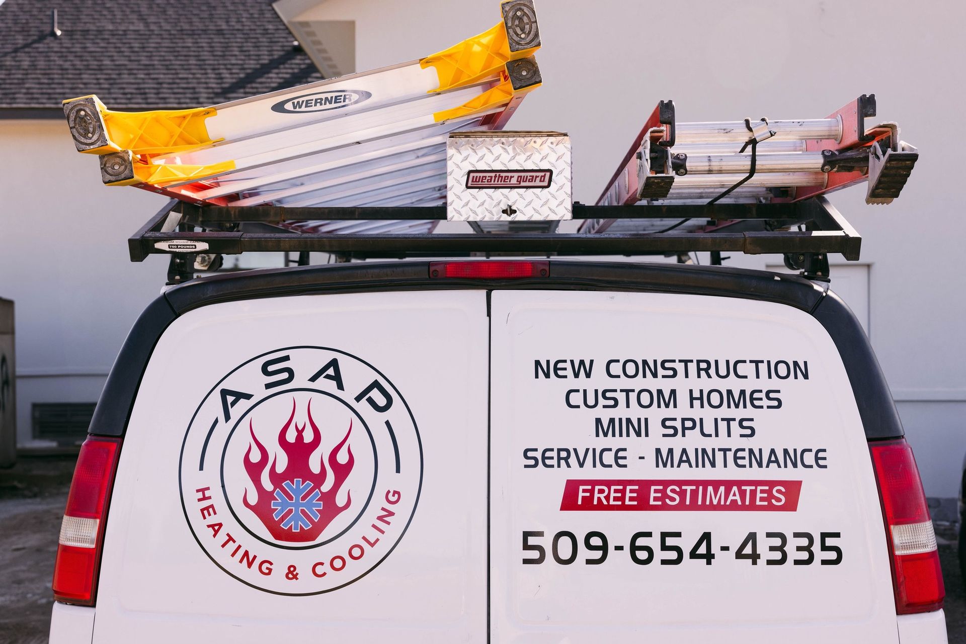 Roofing equipment on a van for ASAD Heating & Cooling; sign advertises construction and service.