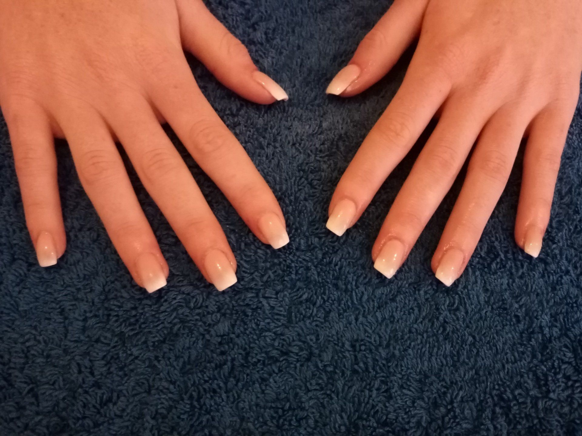 A close up of a woman 's hands on a blue towel