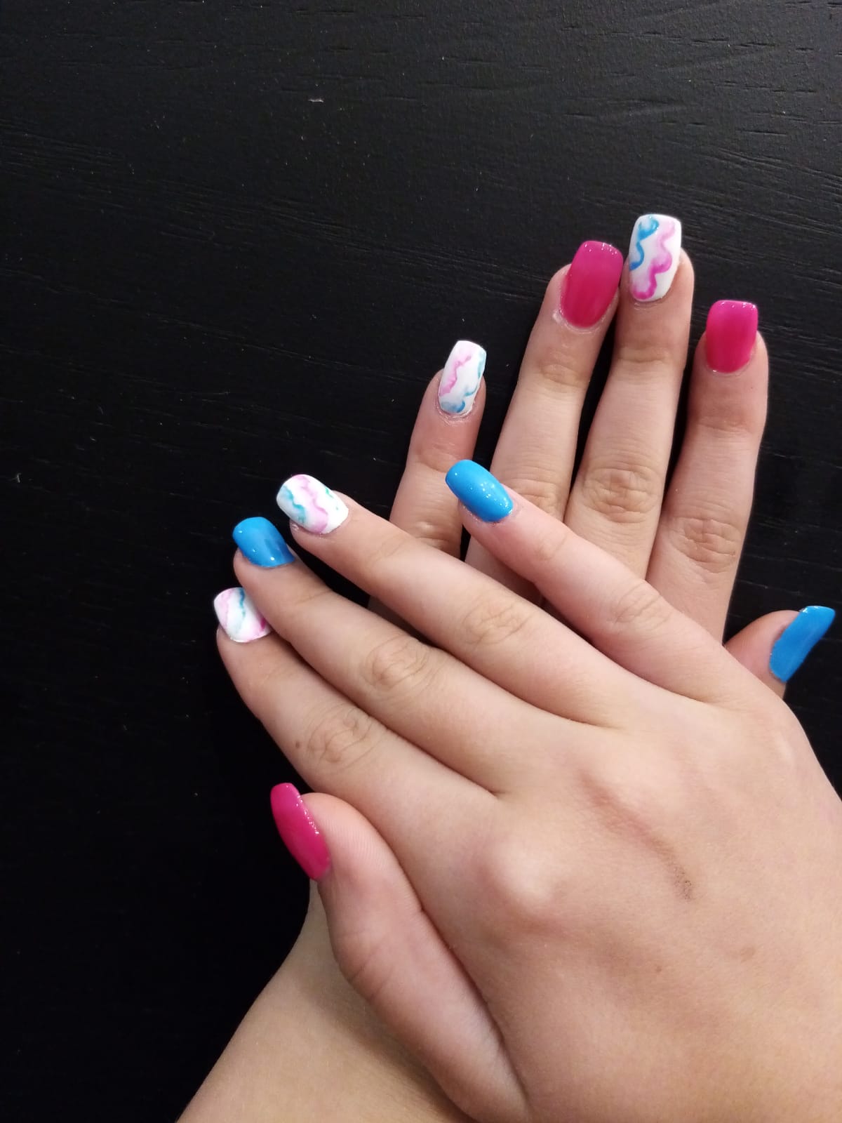A close up of a person 's nails with different colors