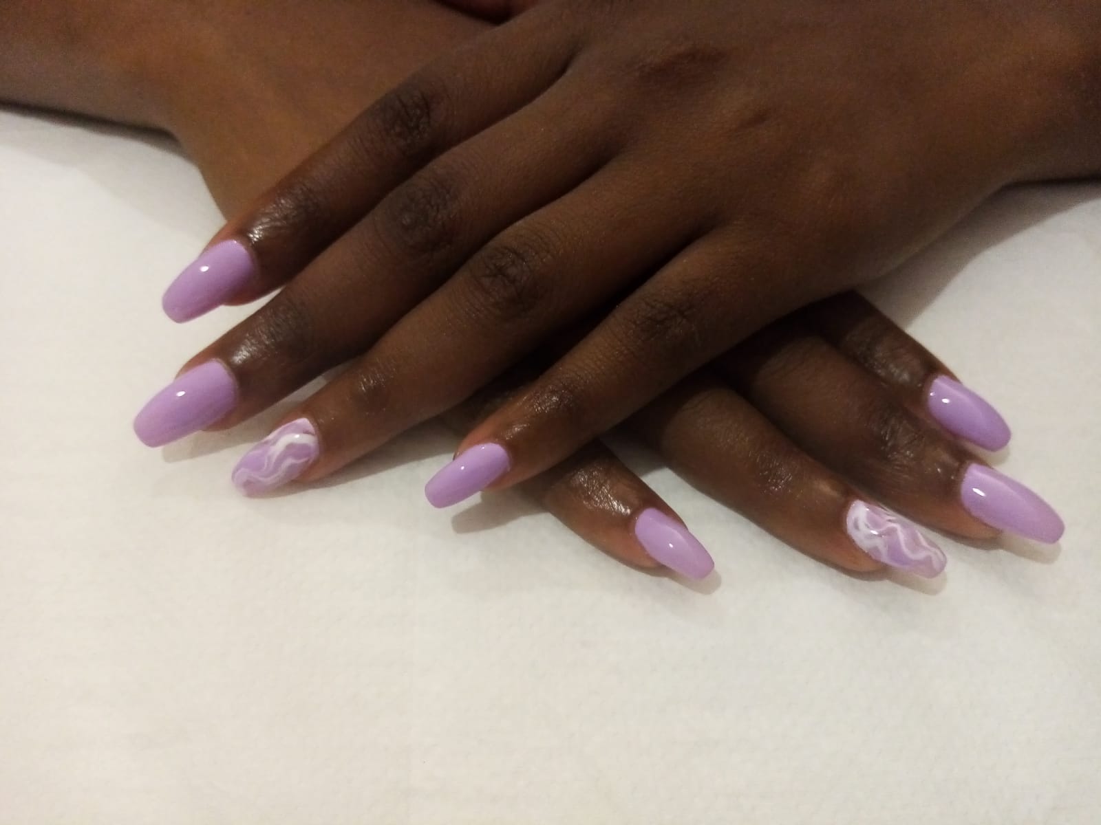 A close up of a woman 's hands with purple nails