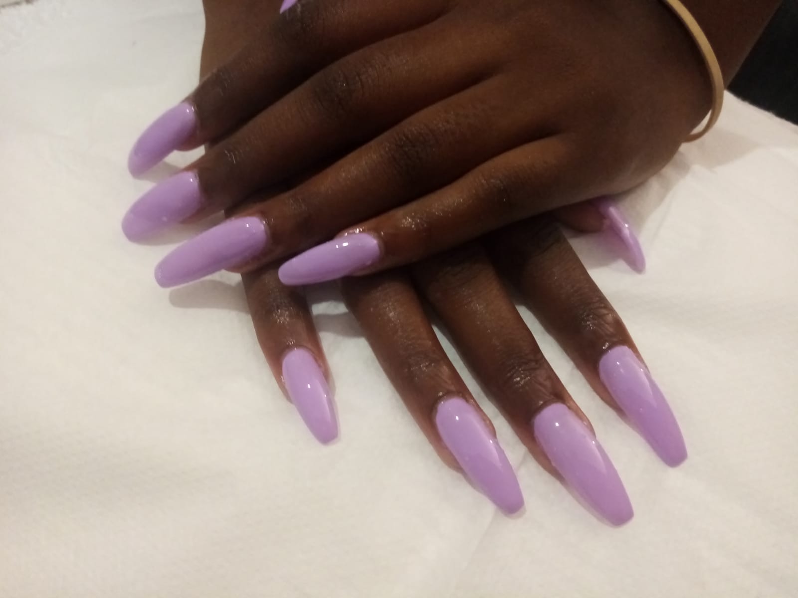 A close up of a woman 's hands with long purple nails