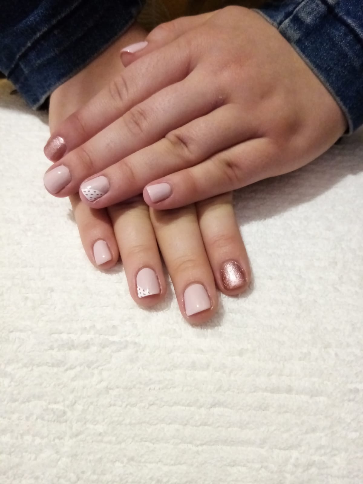 A close up of a person 's hands with pink nails.