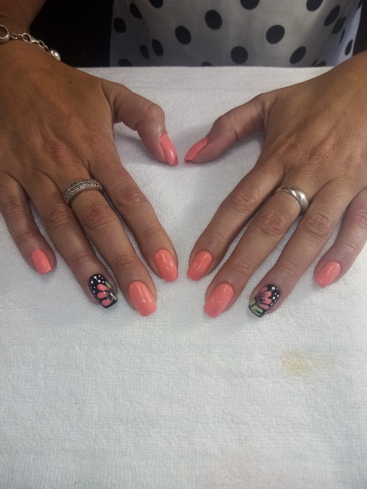 A woman 's hands with pink nails and a butterfly design
