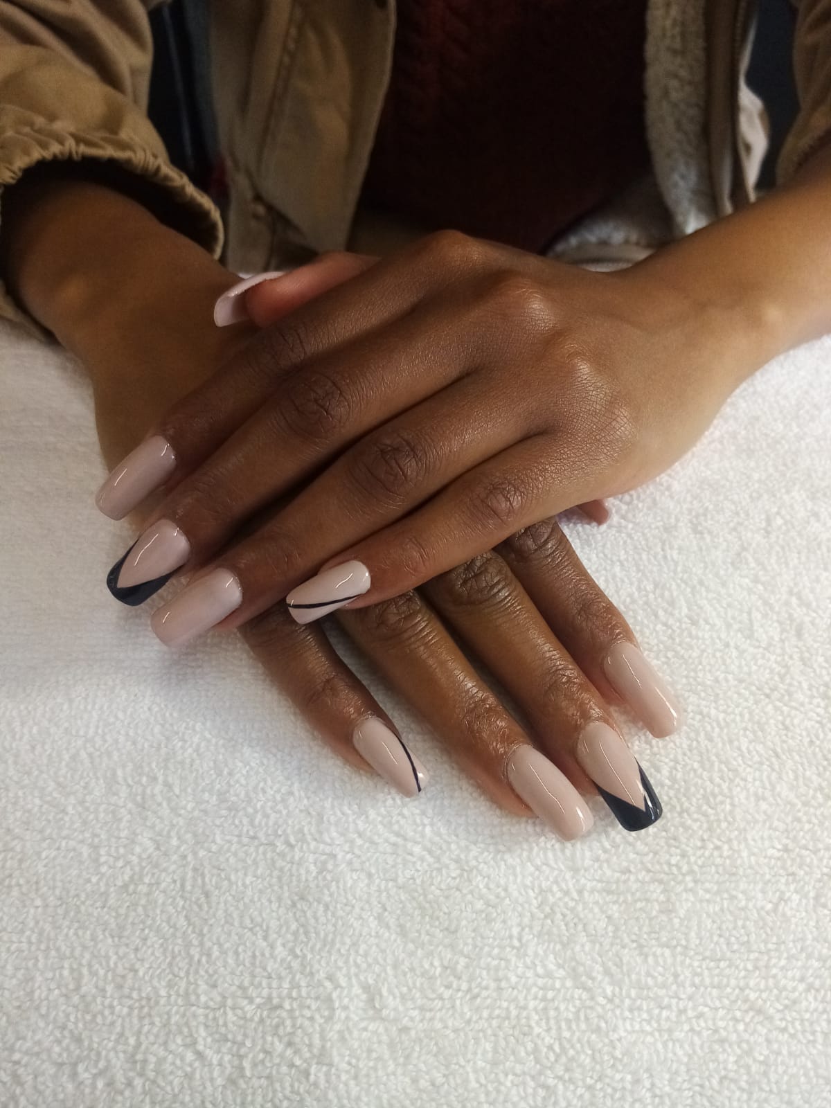 A close up of a woman 's hands with long nails on a white towel.