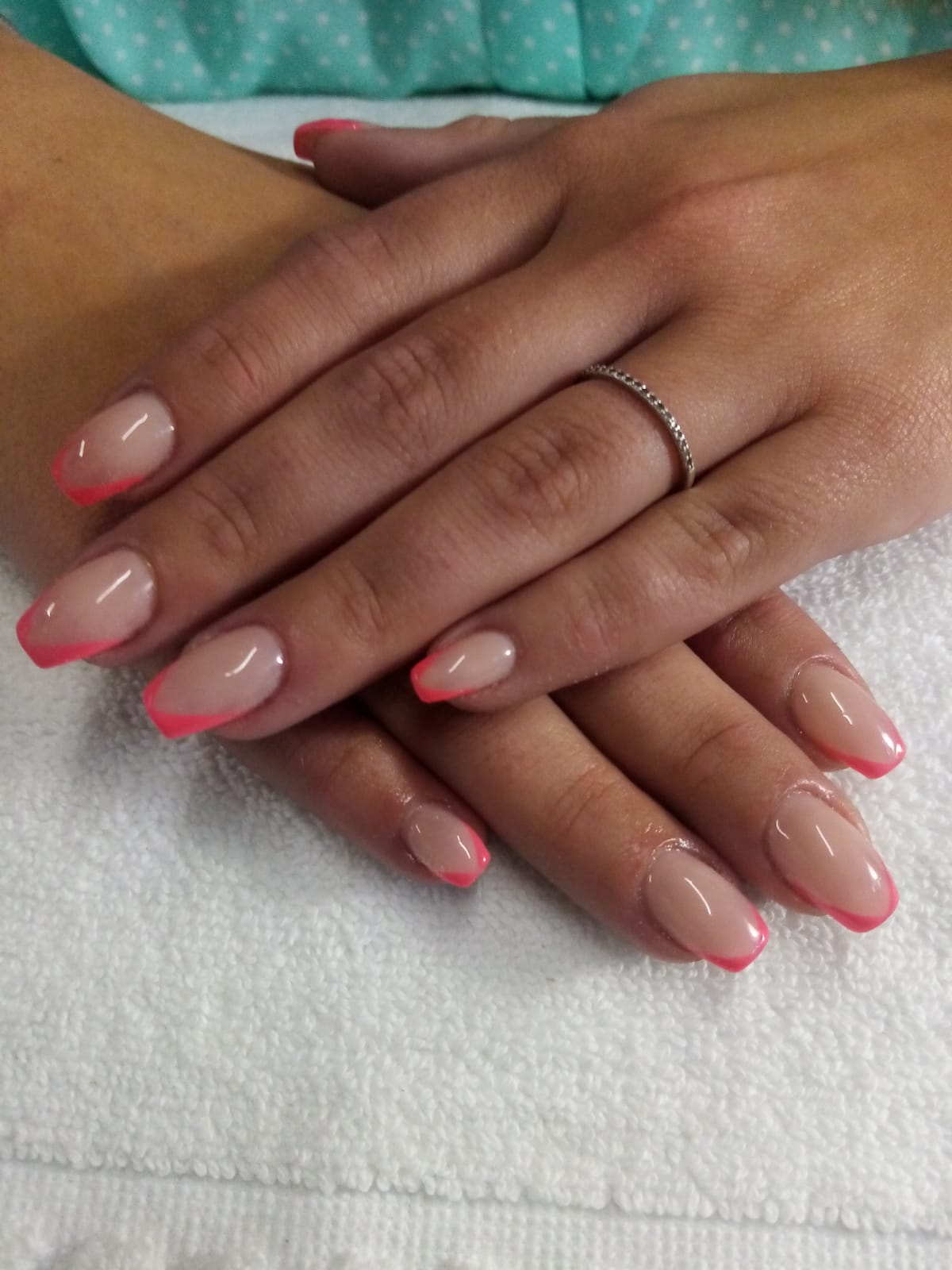A close up of a woman 's nails with a pink french manicure
