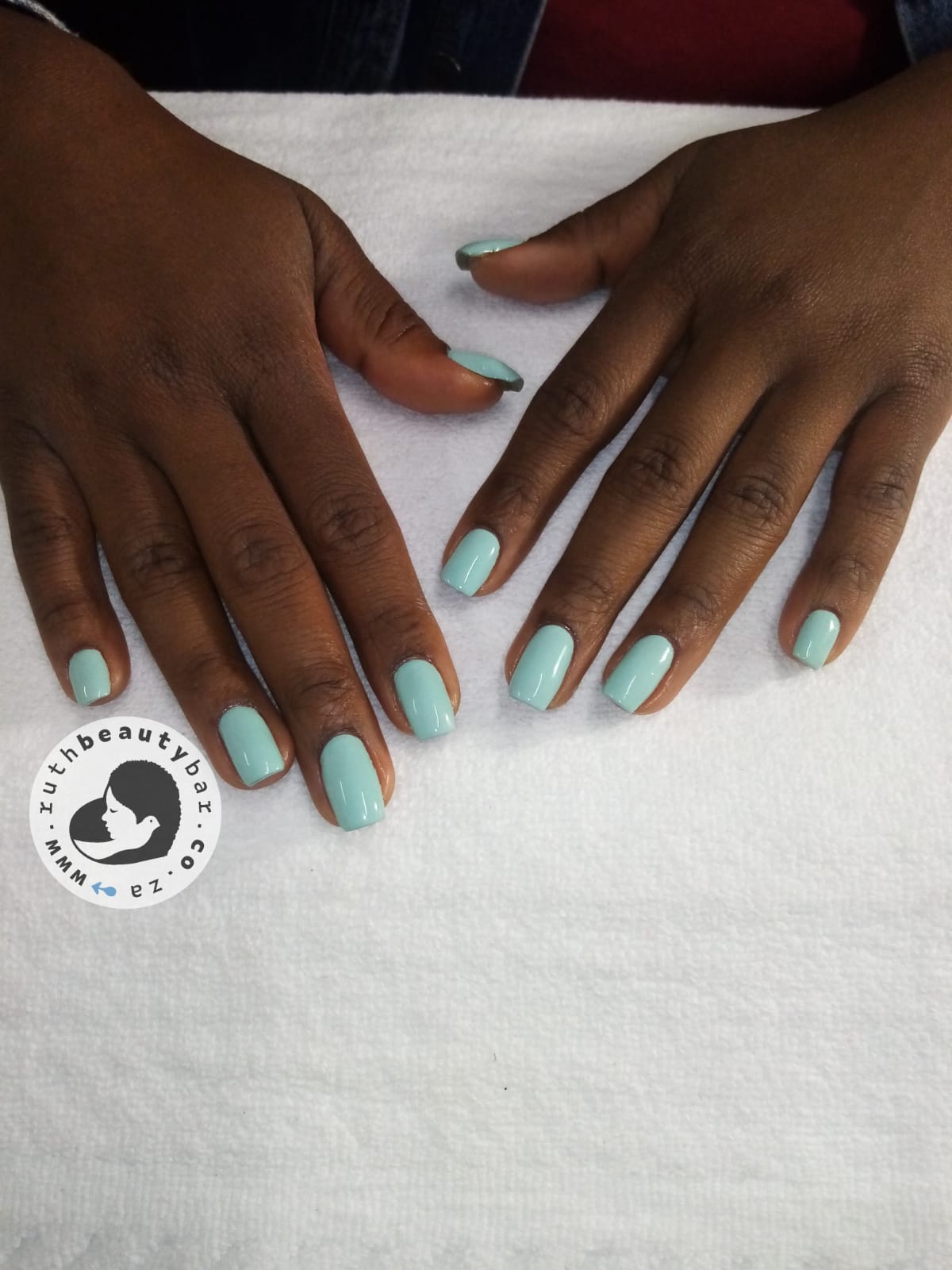 A close up of a woman 's hands with light blue nails