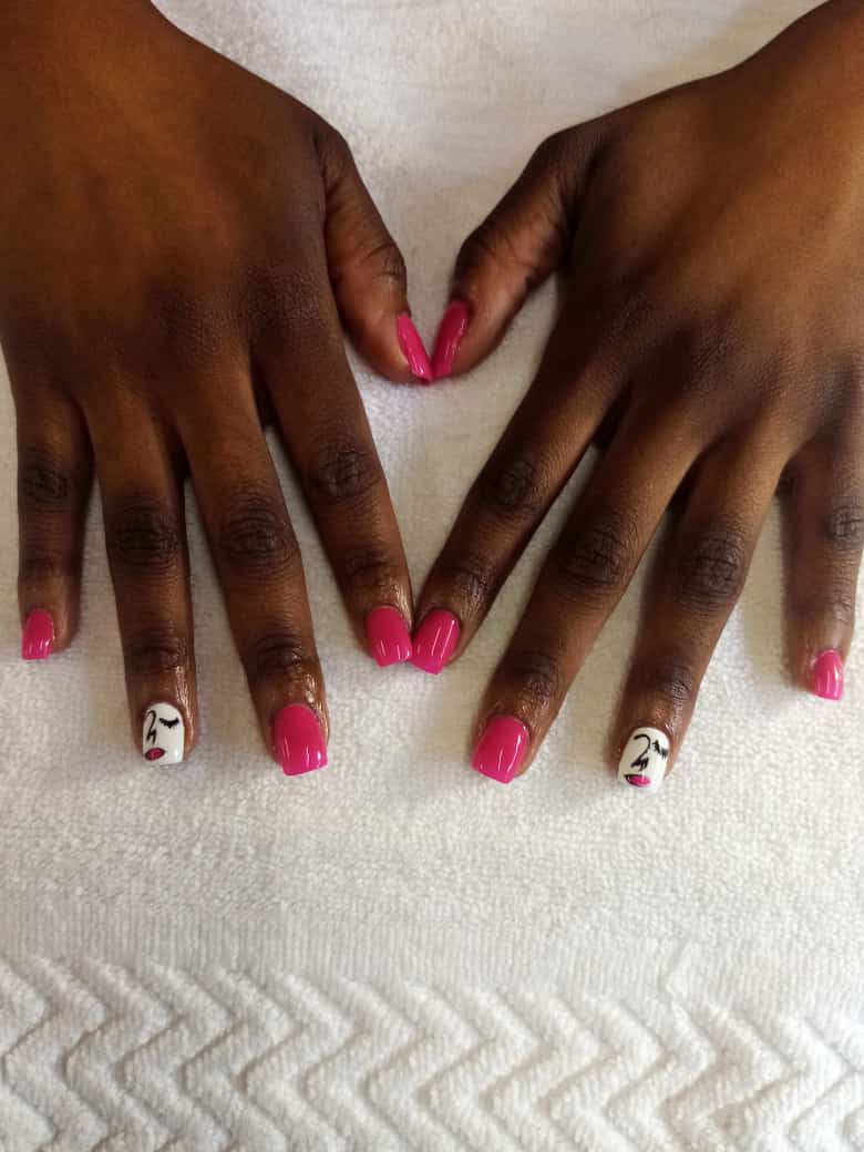 A close up of a woman 's hands with pink nails on a white towel.