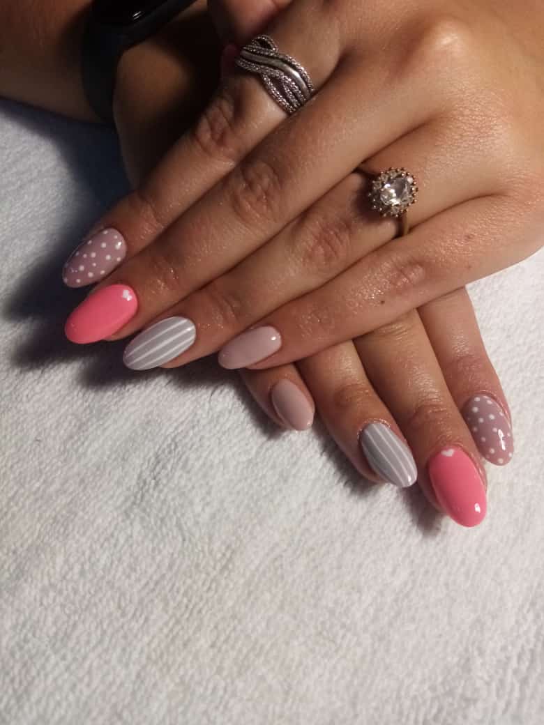 A close up of a woman 's nails with a ring on her finger.
