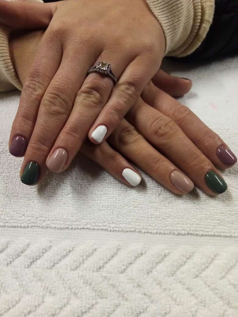 A close up of a woman 's nails with a ring on her finger.