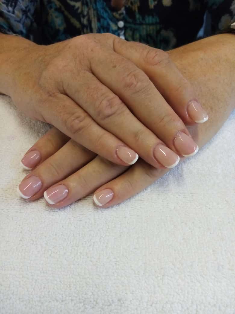 A close up of a woman 's hands with french manicure