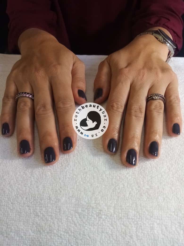 A close up of a woman 's hands with black nails