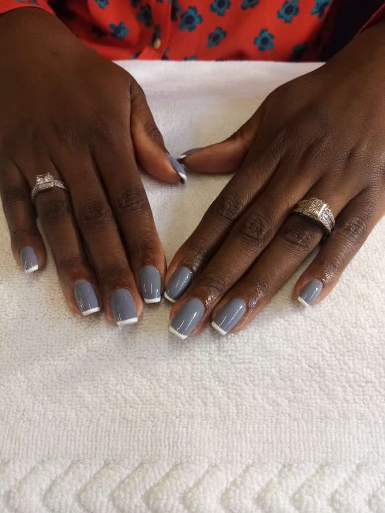 A close up of a woman 's hands with gray nails