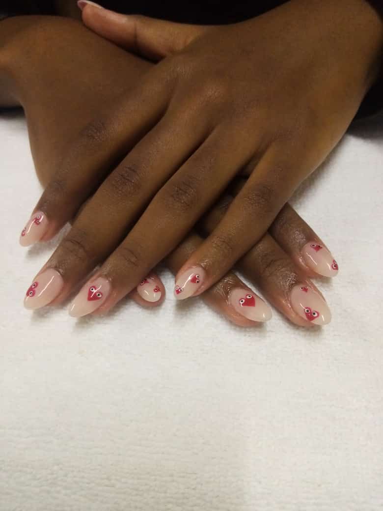 A close up of a person 's nails with hearts on them