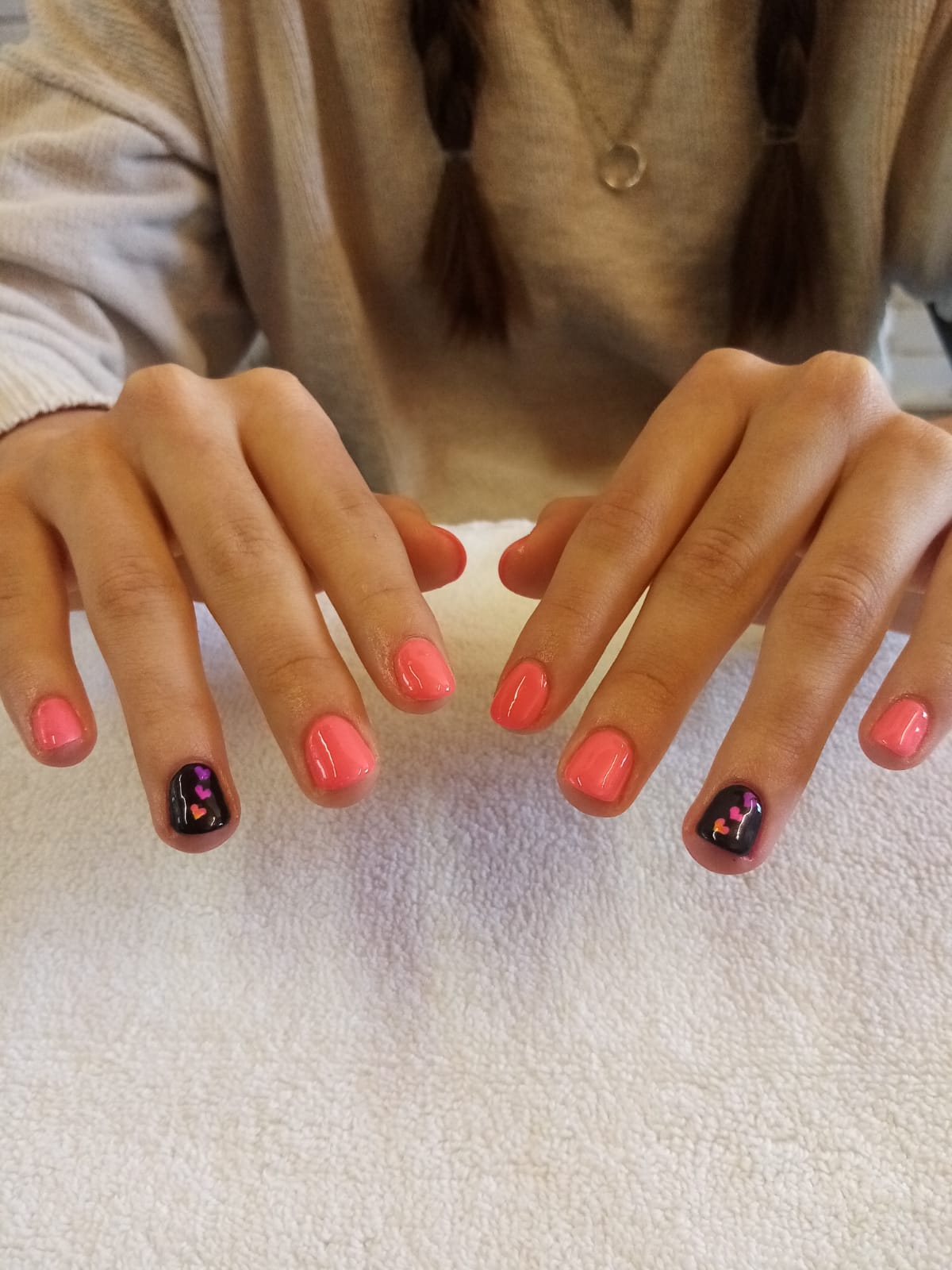 A woman 's nails are painted pink and black