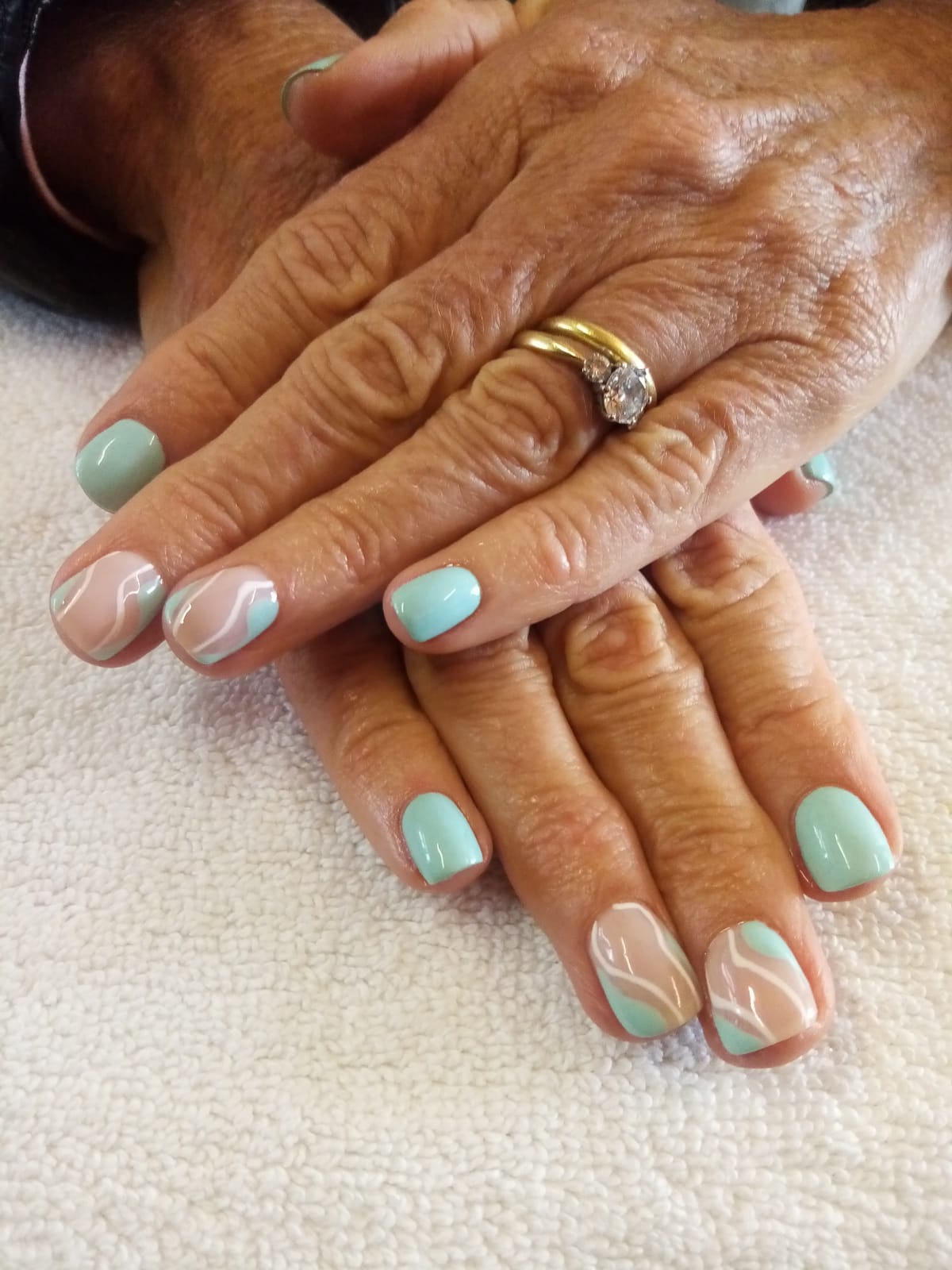 A close up of a woman 's nails with a ring on her finger