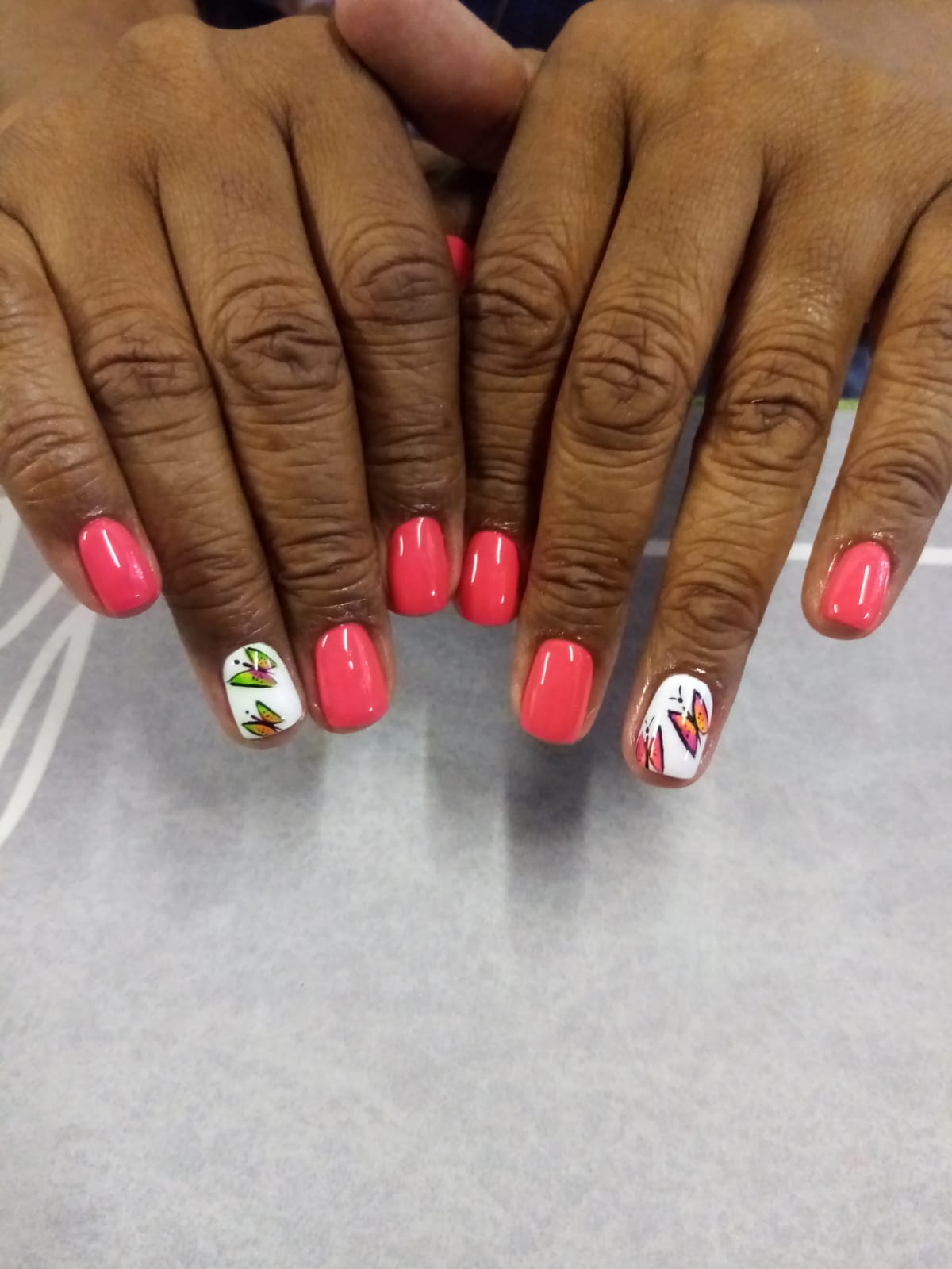 A close up of a woman 's nails with pink nail polish