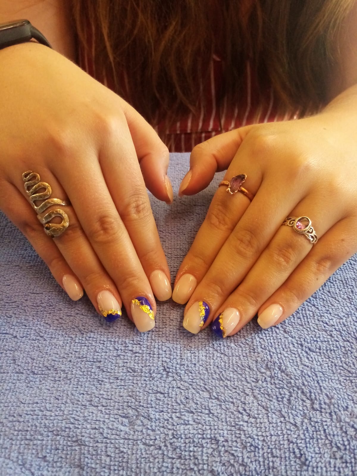A woman 's hands with rings and a name ring