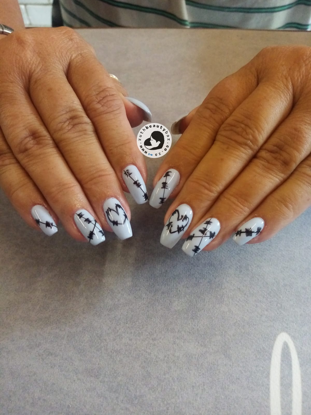 A close up of a woman 's nails with a design on them