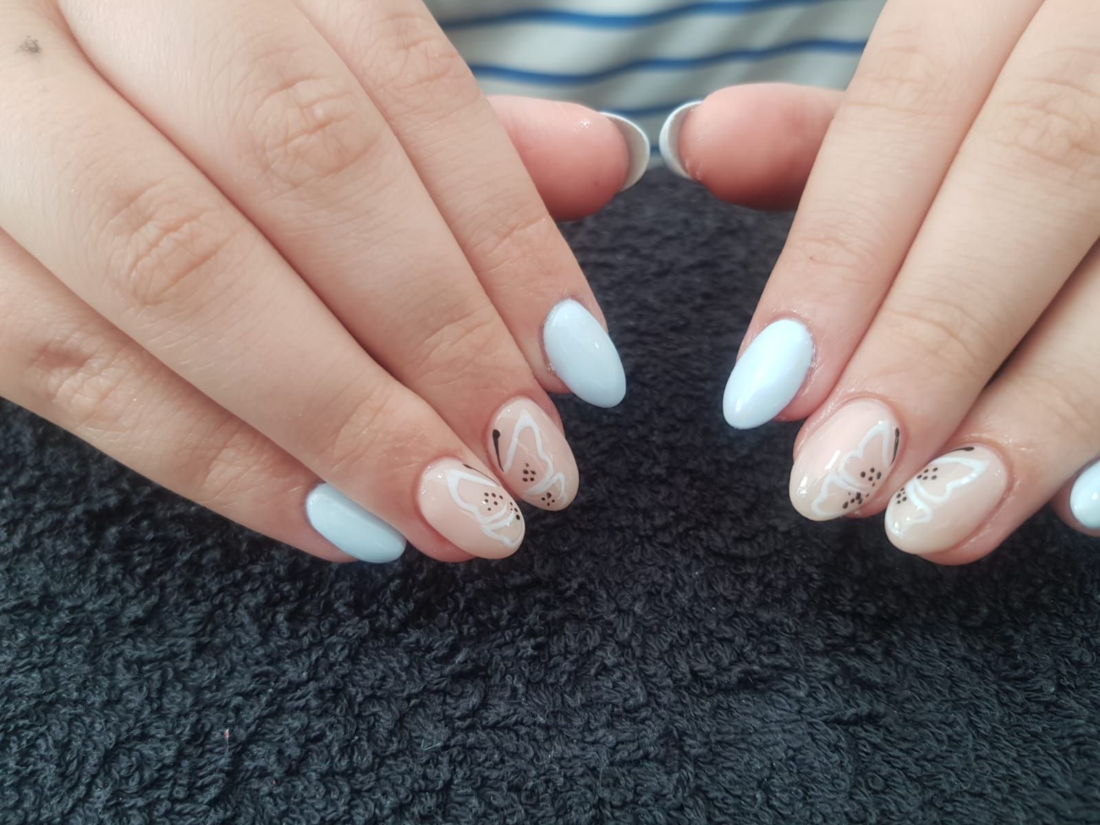 A close up of a woman 's nails on a black blanket
