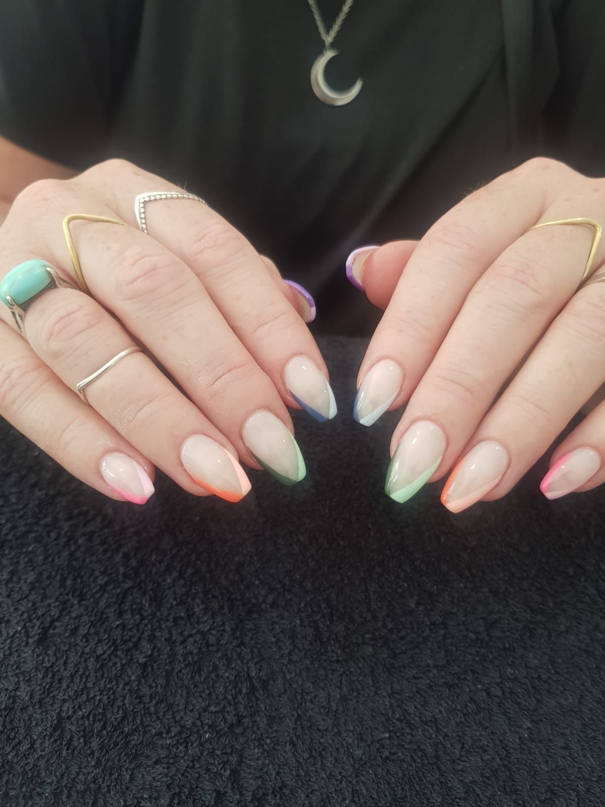 A woman 's hands with long nails and rings on them.