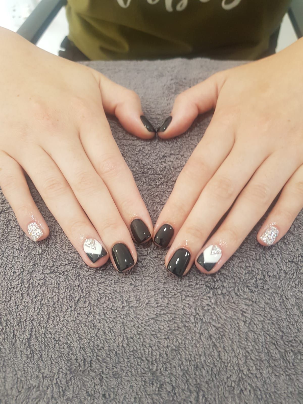 A close up of a person 's hands with black nails