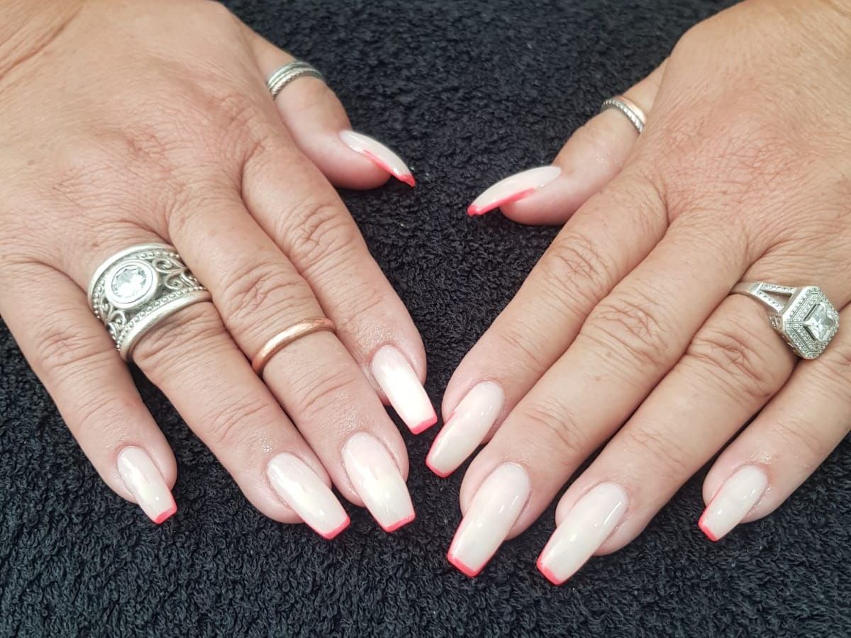An older woman 's hands with long nails and rings on them