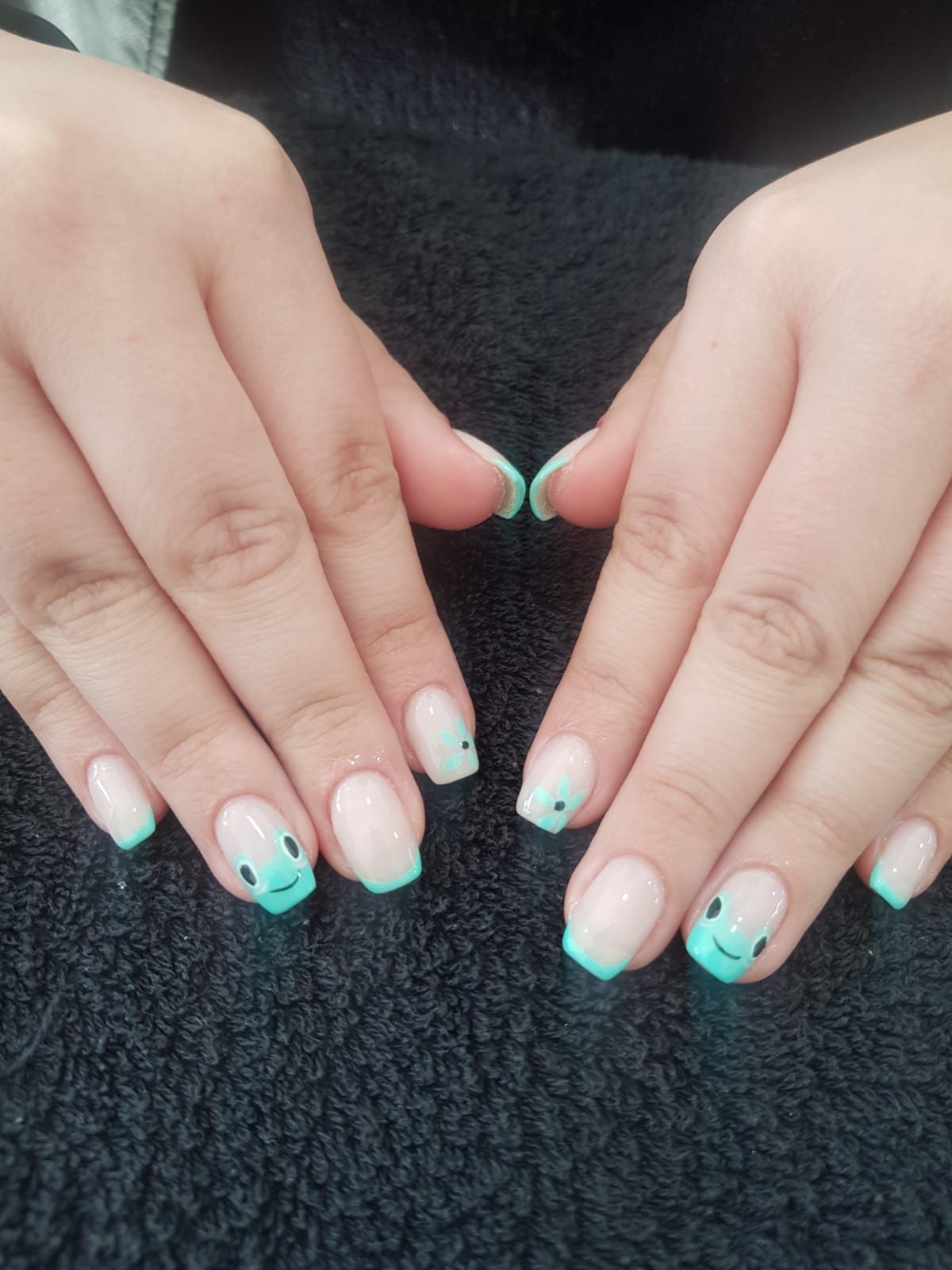 A close up of a person 's nails with a smiley face on them