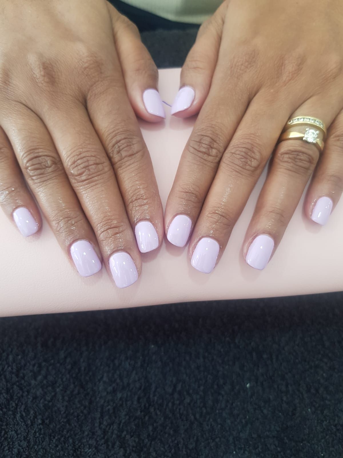 A close up of a woman 's nails with a ring on her finger.