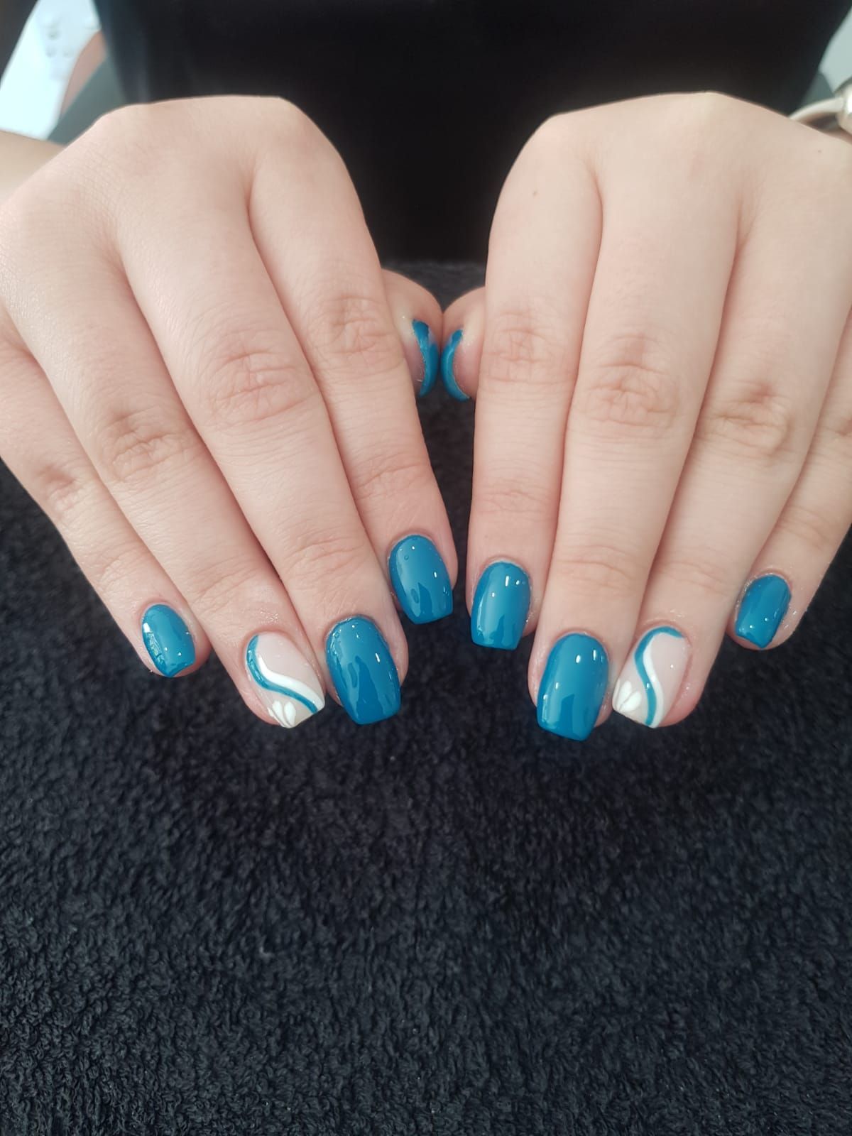 A close up of a person 's hands with blue nails.