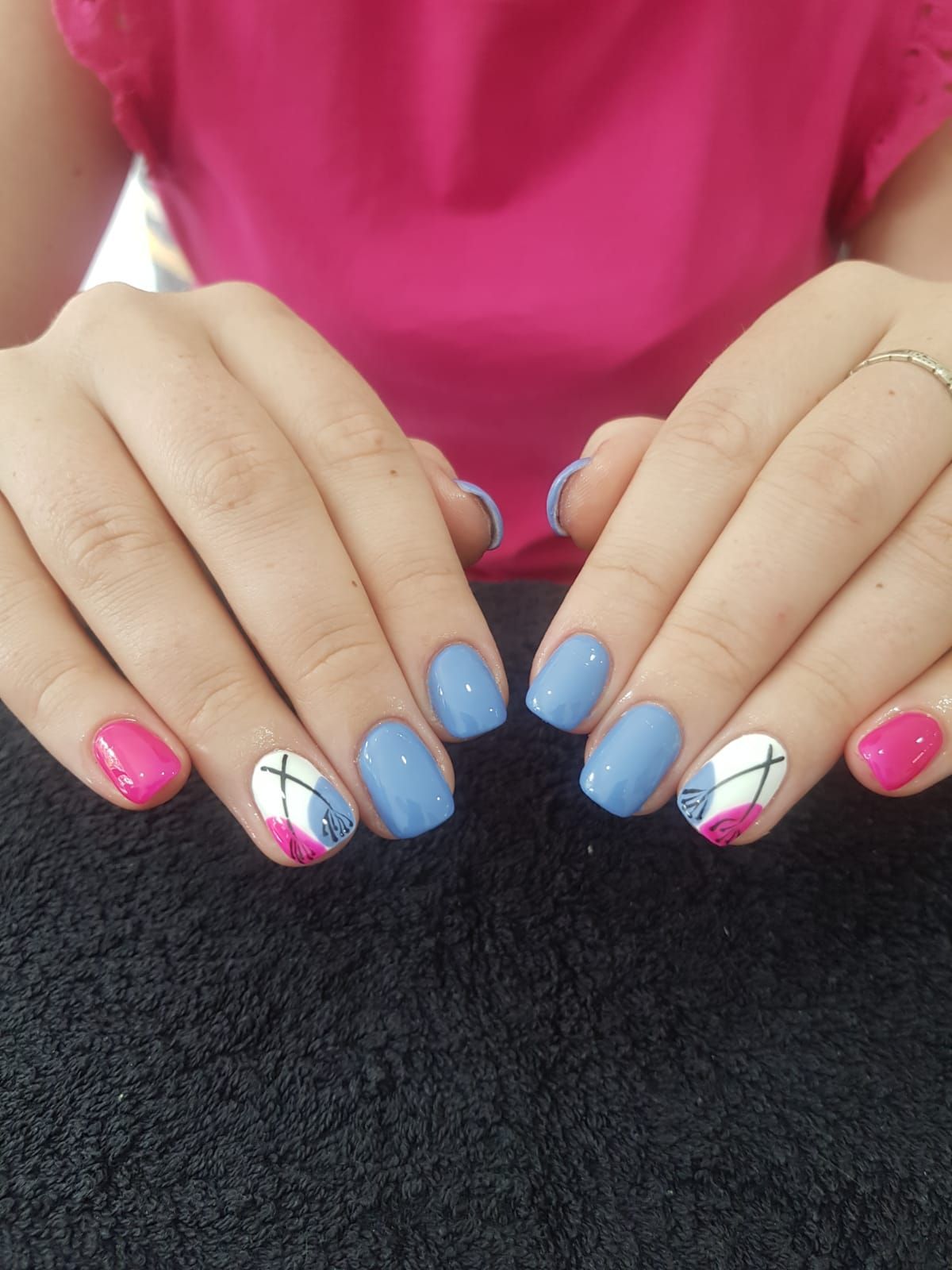 A close up of a woman 's hands with blue and pink nails