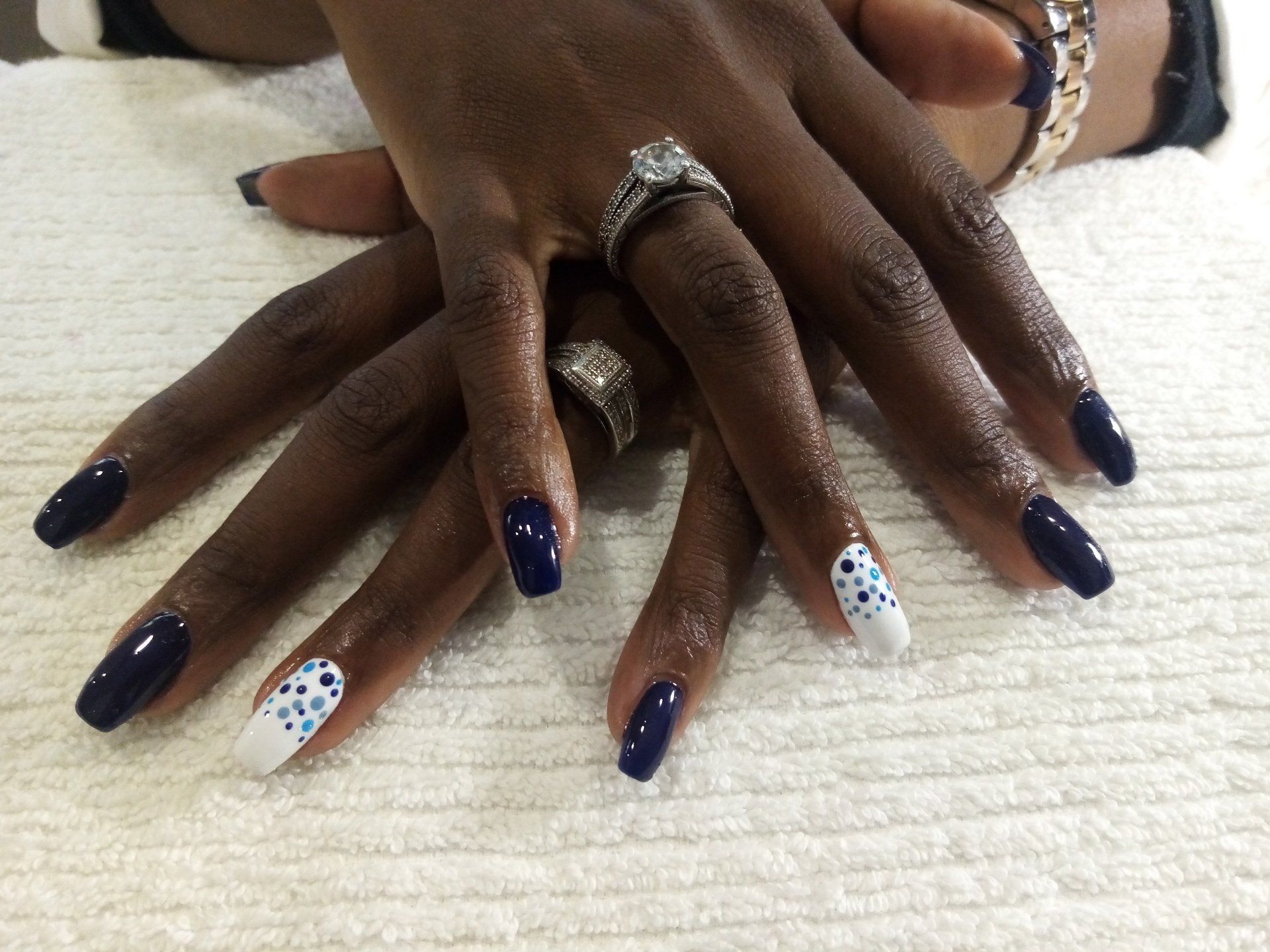A close up of a woman 's nails with a ring on her finger