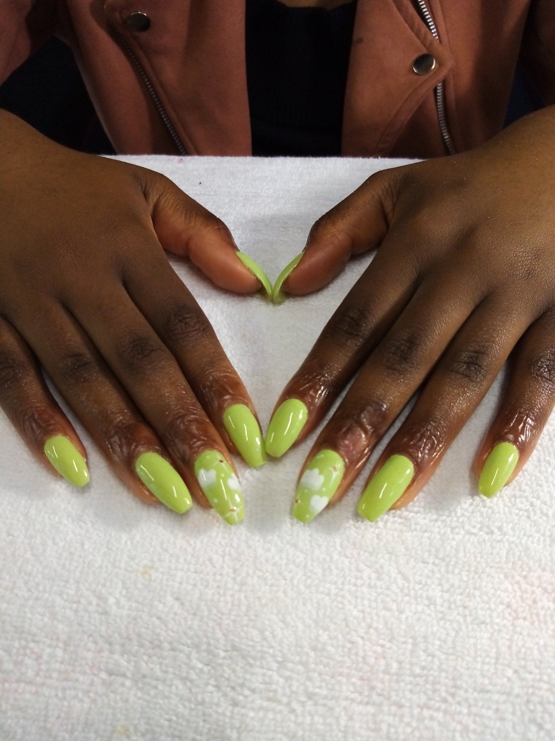 A close up of a person 's hands with green nails