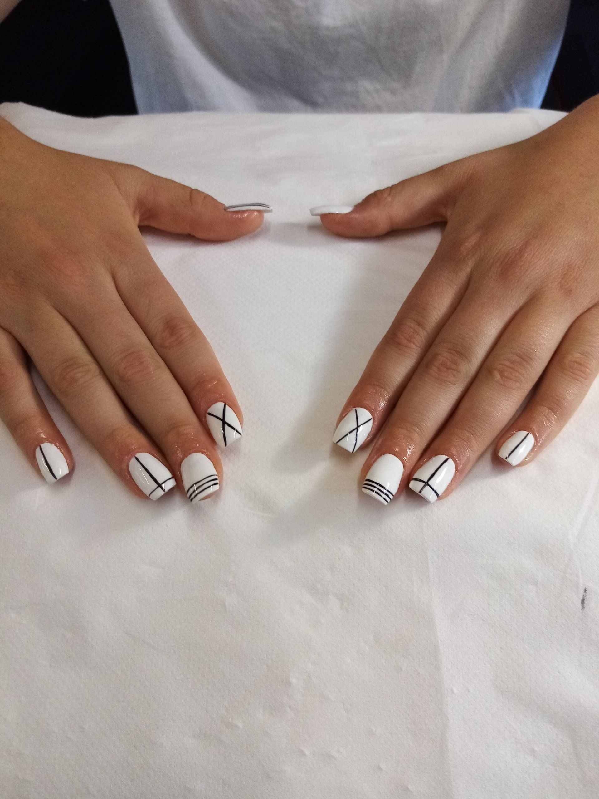 A close up of a person 's hands with white nails