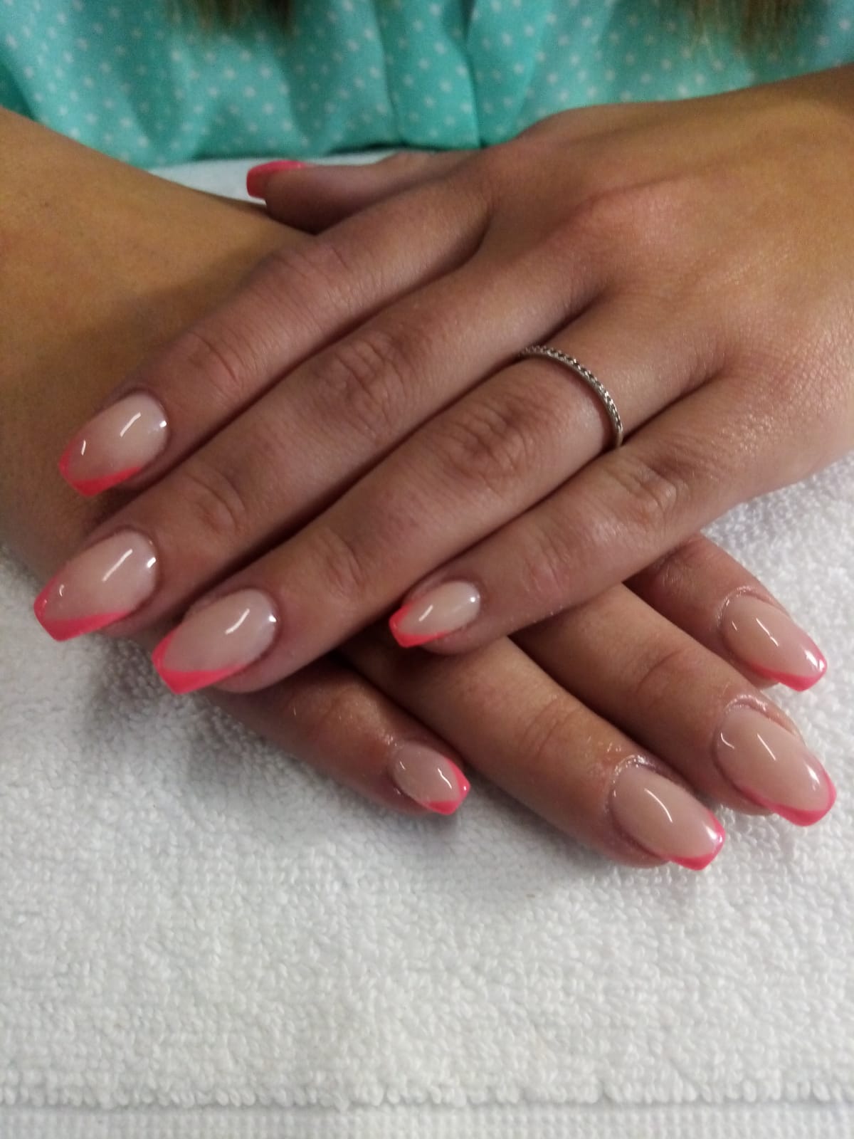 A close up of a woman 's nails with a pink french manicure