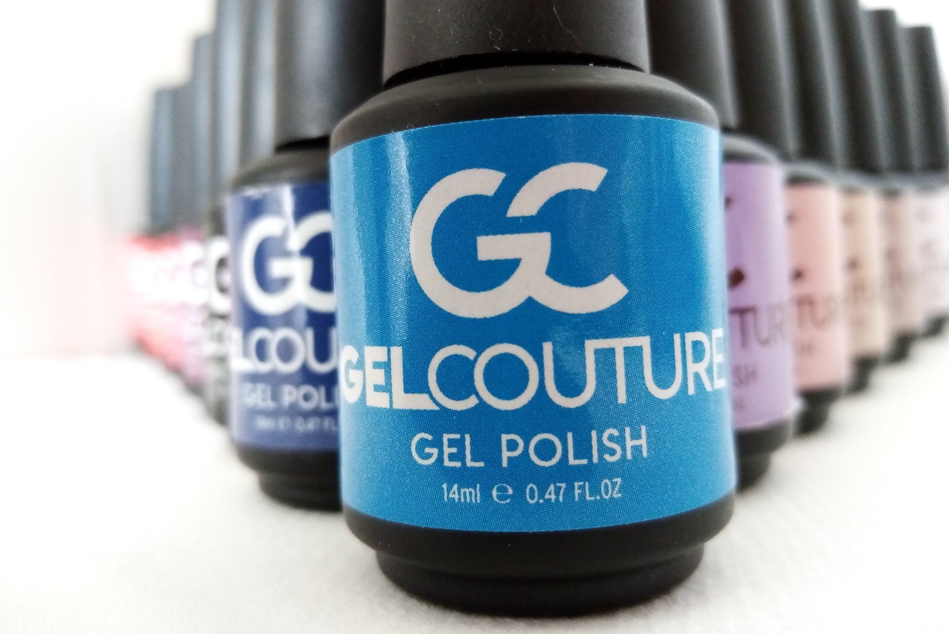 Several bottles of gel polish are lined up on a table
