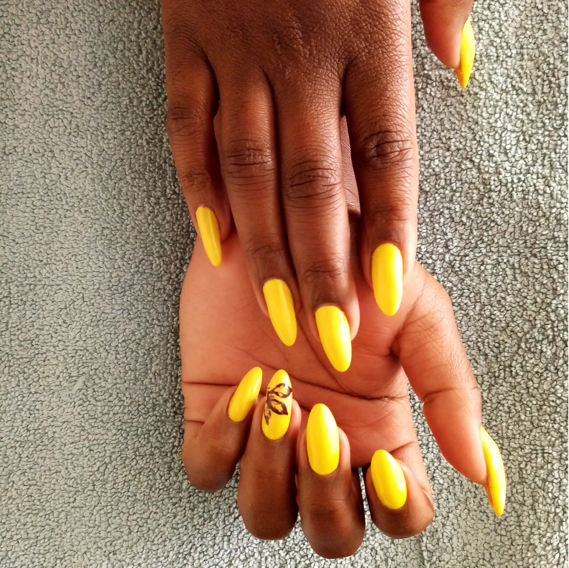 A close up of a woman 's hand with yellow nails