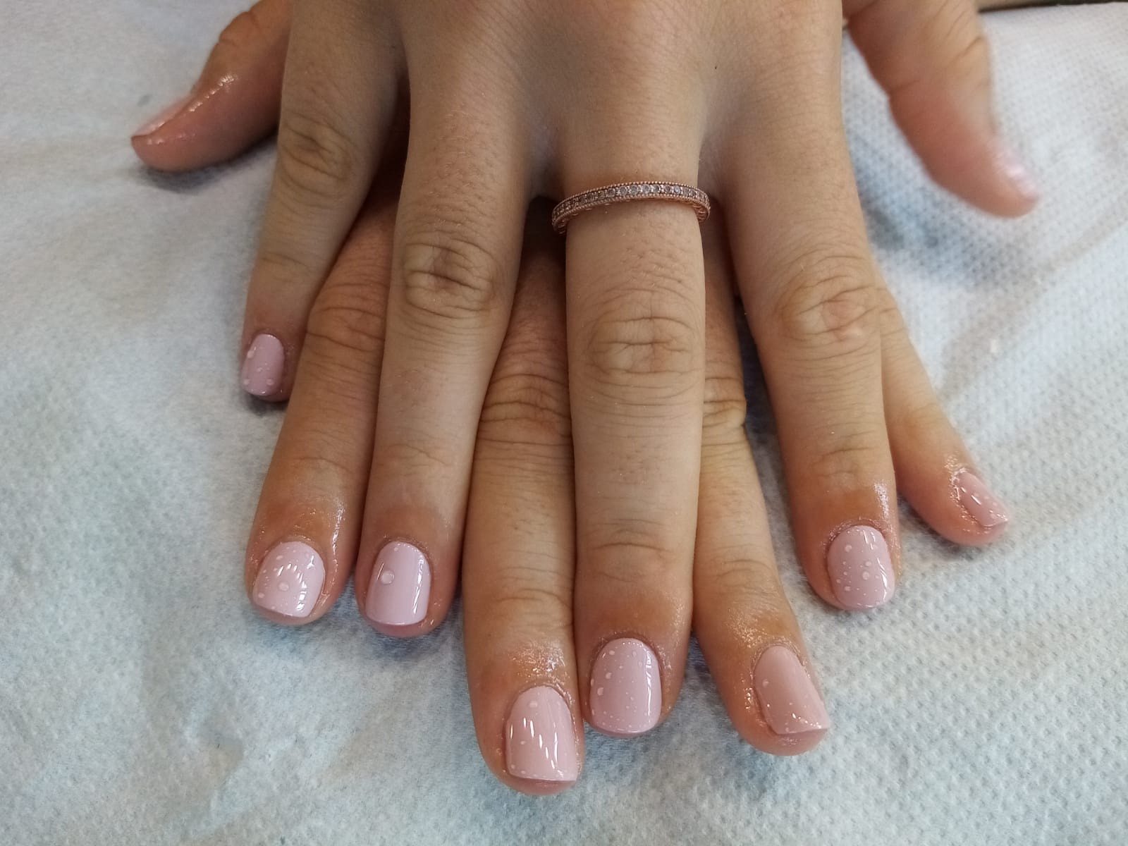 A close up of a woman 's nails with a ring on her finger.