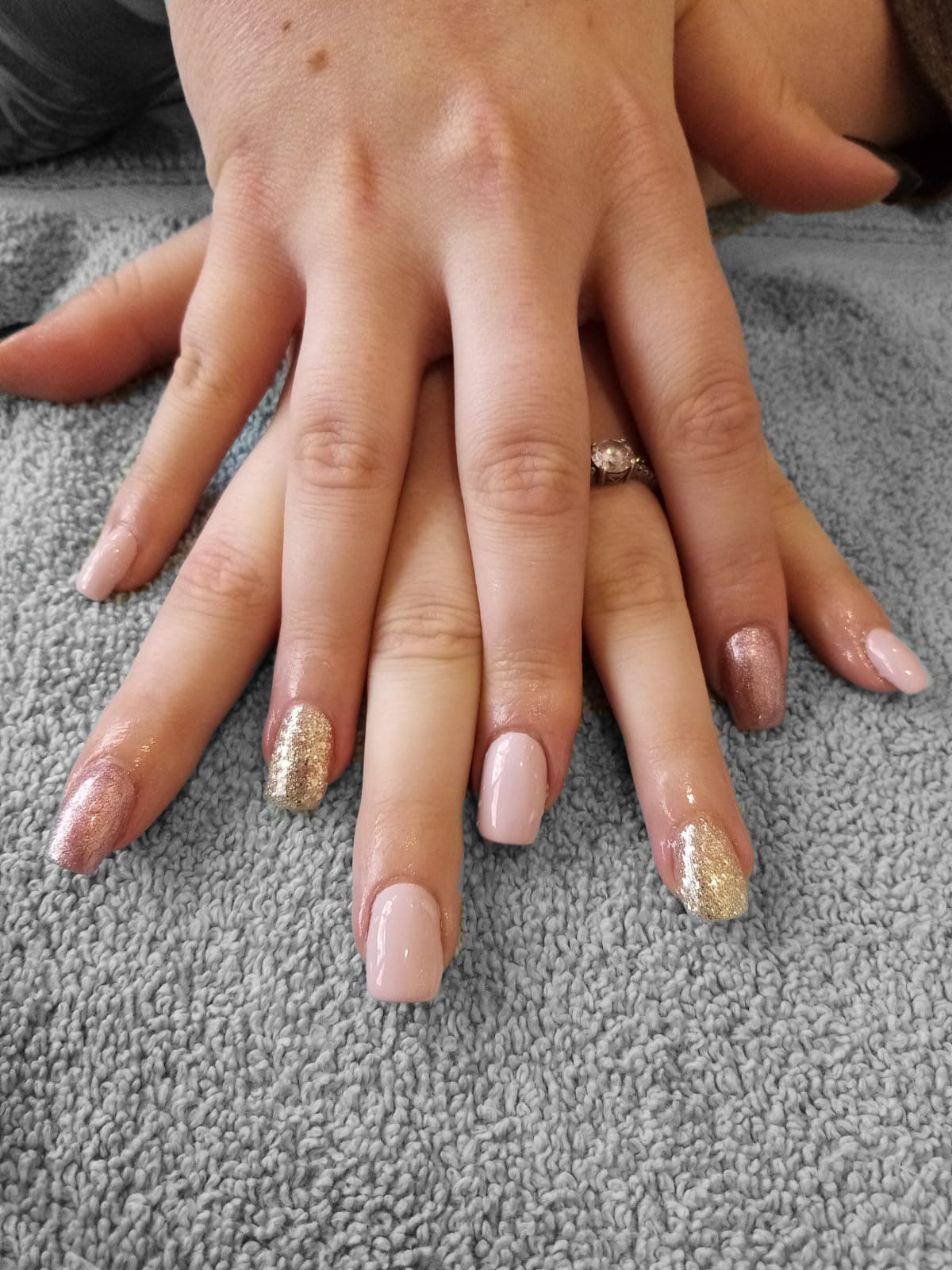 A close up of a woman 's nails with a ring on her finger.