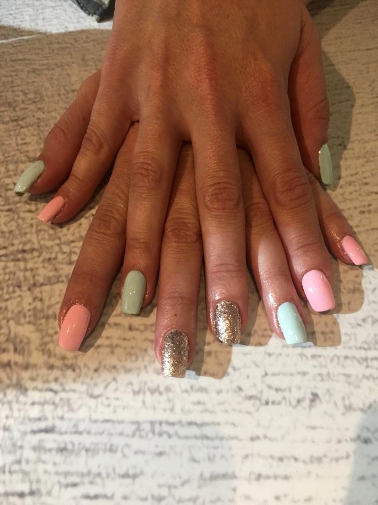 A close up of a woman 's nails on a wooden table.